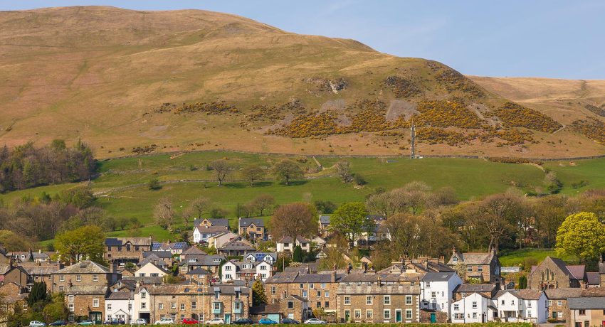 Sedbergh, Yorkshire, UK - 20 April 2019: View of the buildings of the Sedbergh village. Beautiful garden. Sunny spring day. Sedbergh, Yorkshire Dales, UK