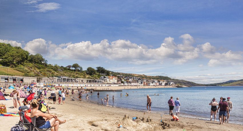 1 July 2017: Lyme Regis, Dorset, England, UK - Sandy Beach on a hot sunny summer day.